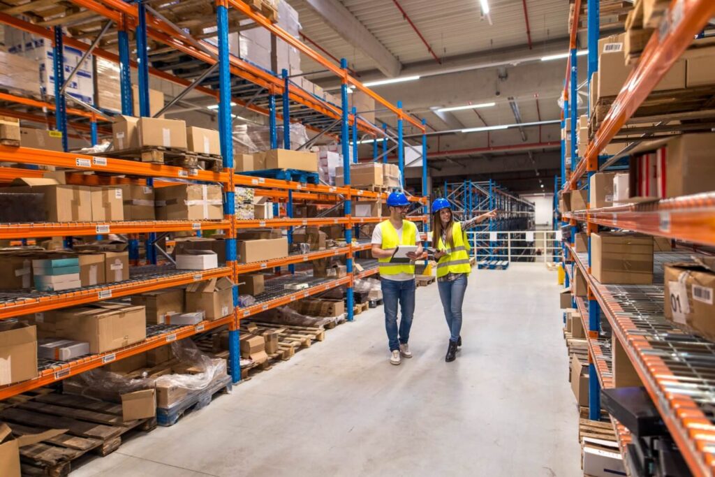 imgi 53 two warehouse workers walking distribution storage area discussing about logistics organization